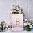 Rose gold table number holder with floral arrangement and number 8.