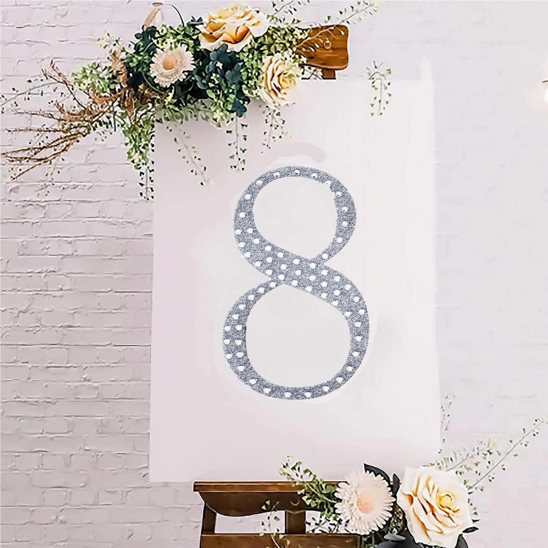 Decorative number 8 with floral accents on an easel.