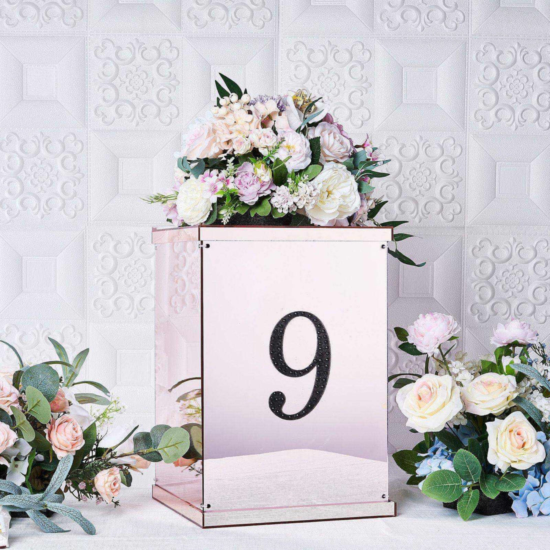 Mirrored table centerpiece with floral arrangement and number 9.