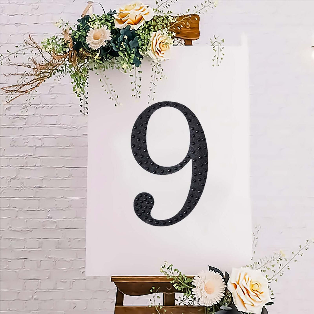 Decorative number 9 on an easel with flowers, ideal for events or celebrations.