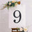 Decorative number 9 on an easel with flowers, ideal for events or celebrations.