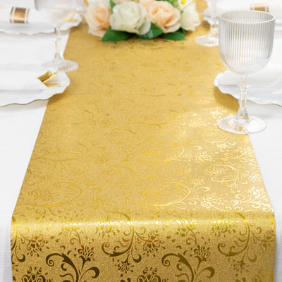 Gold table runner with elegant floral design on a dining table.