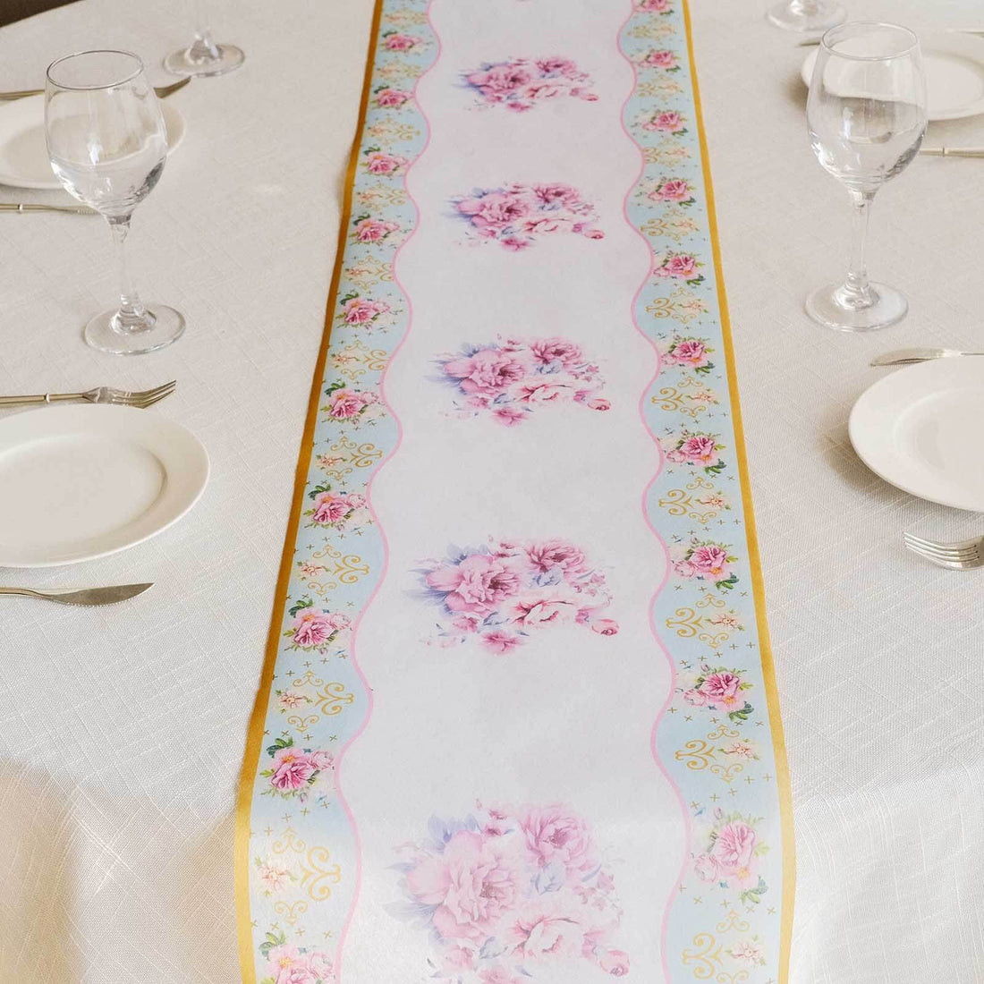 Floral table runner with pink flowers on a light background.