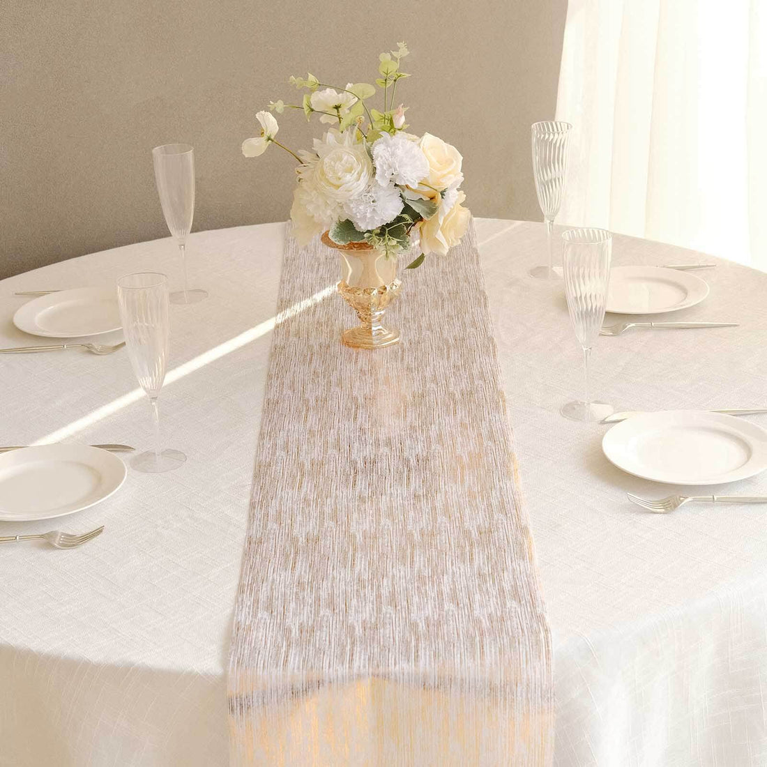 Elegant table setting with floral centerpiece and white table runner.