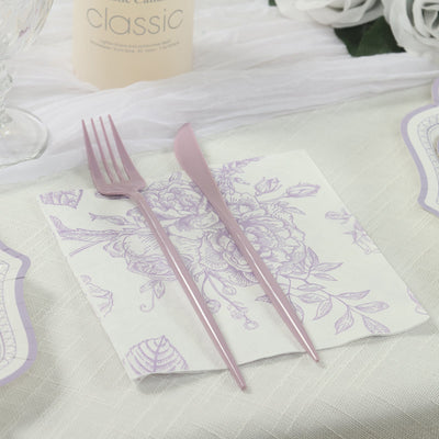 Lavender fork and knife on a floral napkin at a dining table setting.