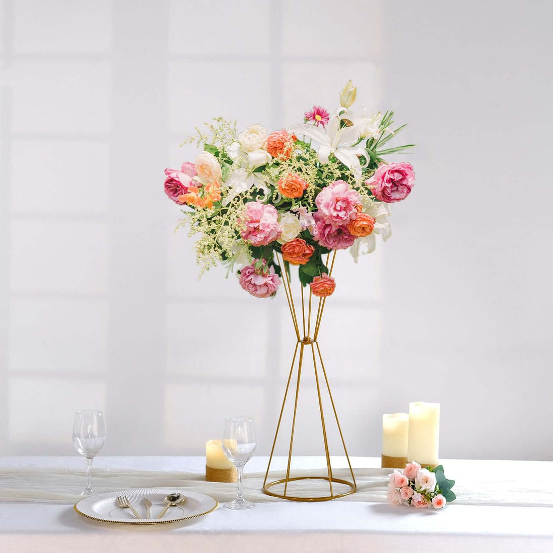 Artificial floral arrangement in a modern gold stand on a dining table.