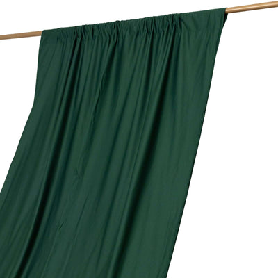 Green curtain draped on a rod, showcasing smooth fabric texture.