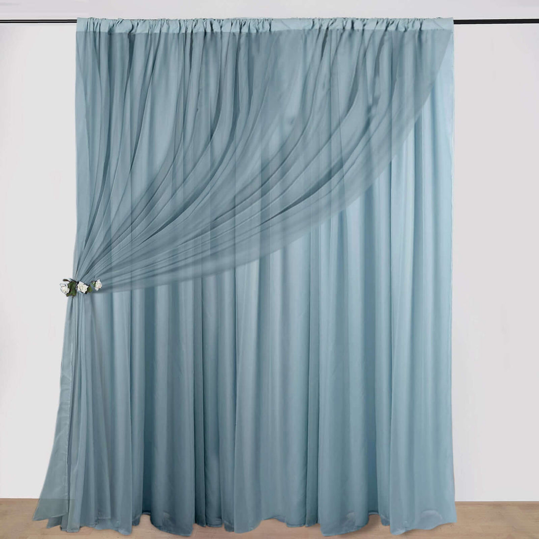 Sheer blue curtain with gathered drapes and floral tieback