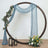 Decorative wedding arch with draped fabric, lanterns, and floral arrangements.