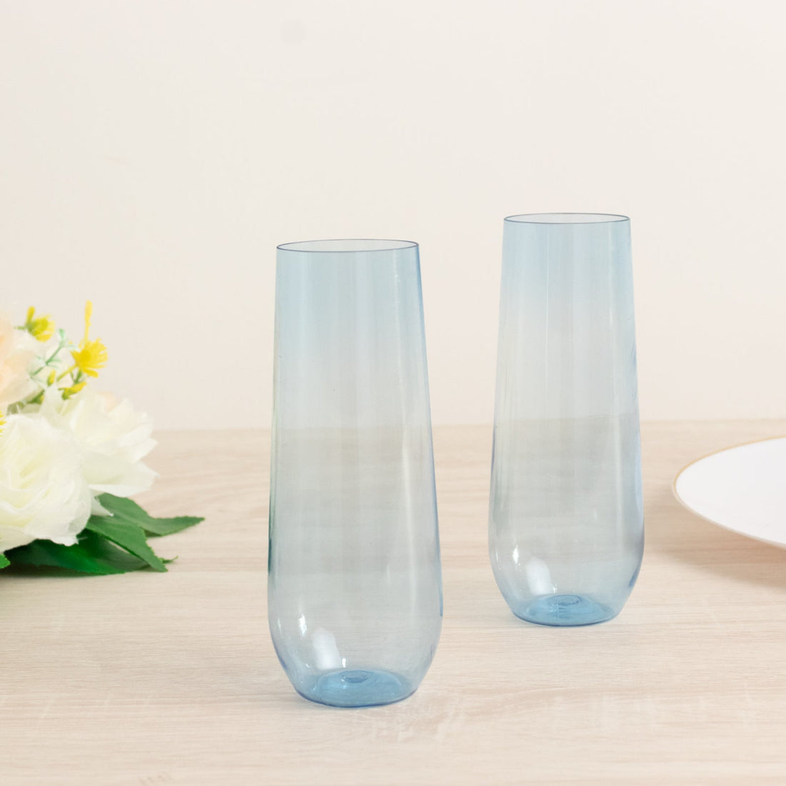 Two elegant blue champagne flutes on a wooden table.