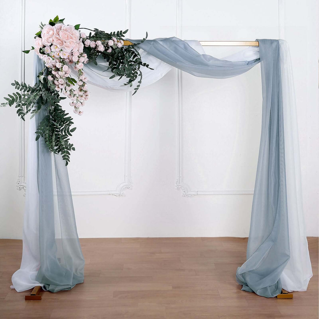 Wedding arch with soft drapes and floral arrangement.