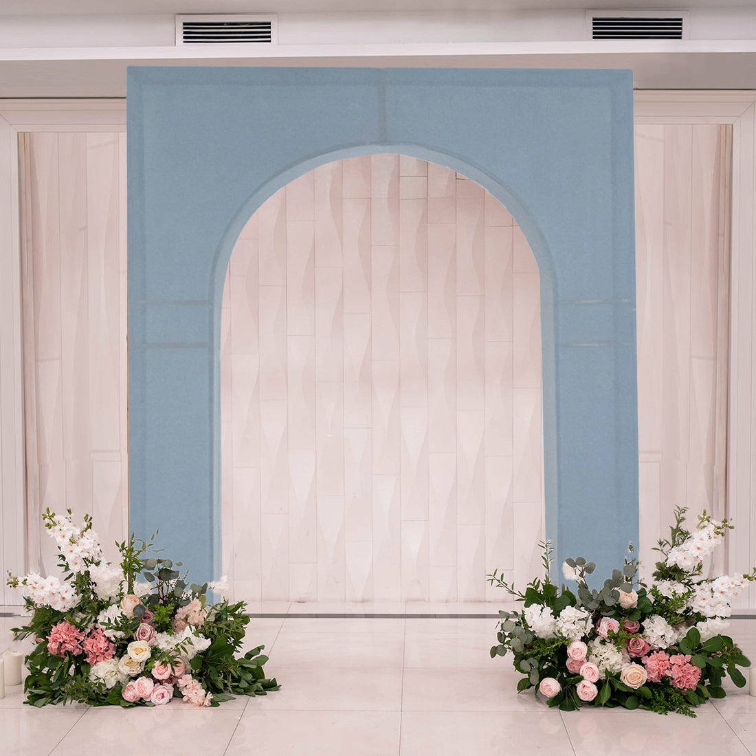 Blue arch with floral arrangements at the base, perfect for events or weddings.