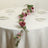 Floral table centerpiece with pink and purple blooms on a dining table.
