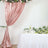 Elegant pink satin curtain with floral decor for event styling.