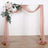 Elegant wedding arch draped in soft fabric with floral accents.