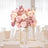 Elegant pink floral centerpiece on a dining table in a bright venue.
