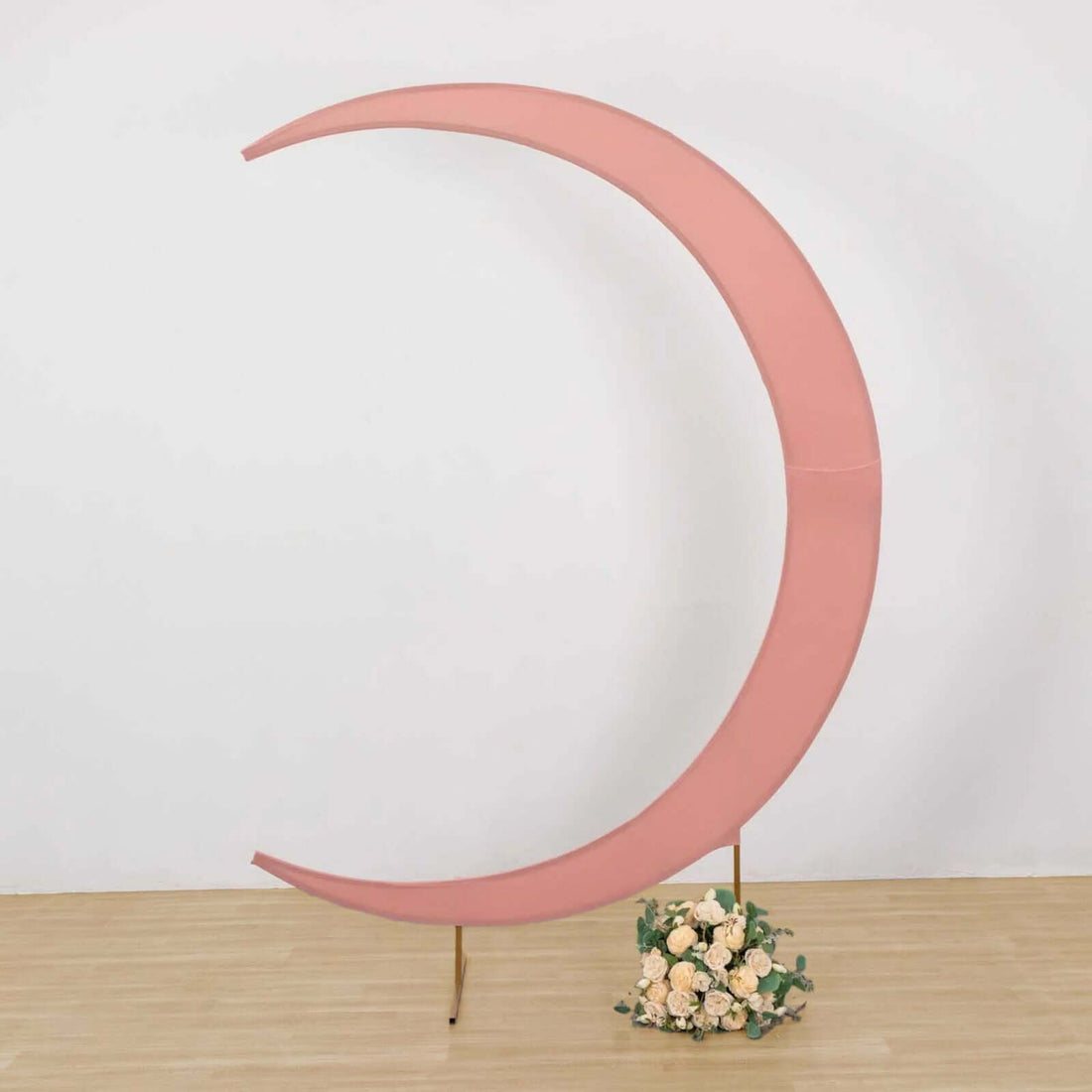 Pink crescent moon backdrop with floral arrangement at the base