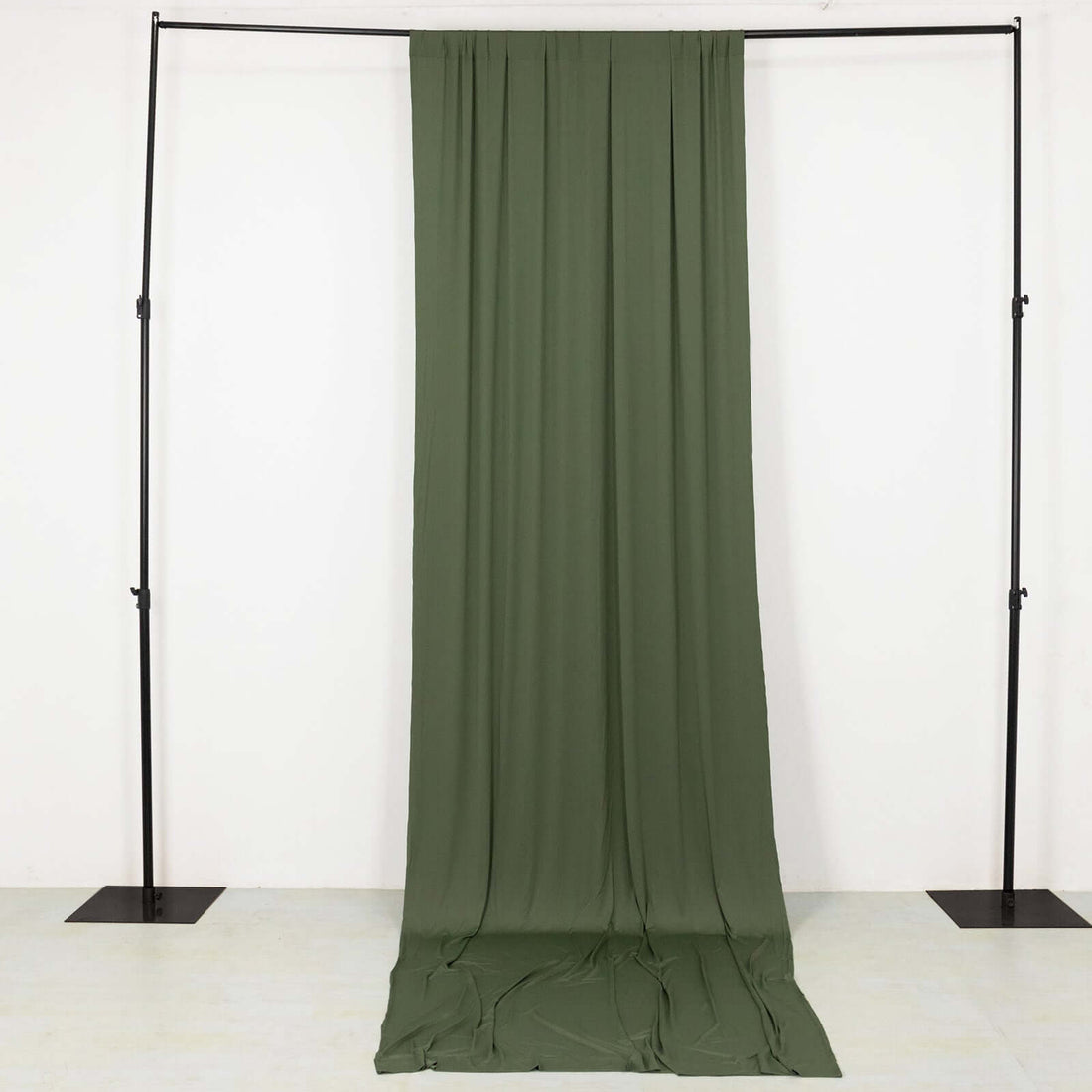 Olive green fabric draped on a black backdrop stand