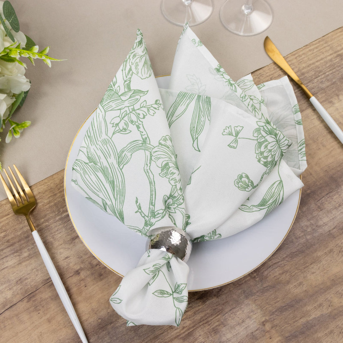 Floral patterned napkin elegantly arranged on a plate with cutlery.