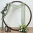 Circular floral backdrop with draped fabric and lanterns for events or photography.