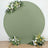 Green round backdrop with floral arrangements on two sides.