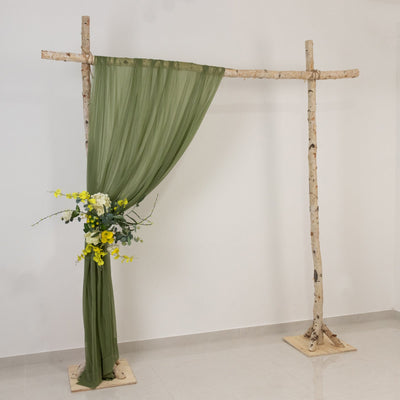 Green drapery backdrop with floral arrangement on a wooden frame.