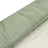 Green textured fabric roll on a white background.