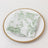 Green floral napkin on a decorative plate.