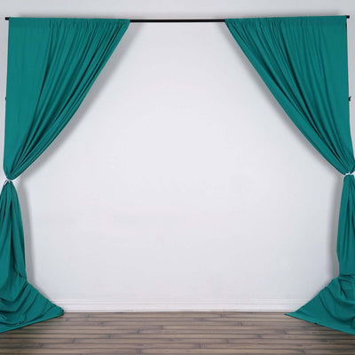 Teal fabric curtains hanging from a black rod against a white wall