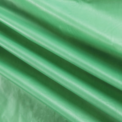 Green textured fabric with folds and creases.