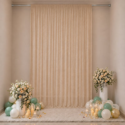 Elegant beige party backdrop with floral arrangements, balloons, and candles