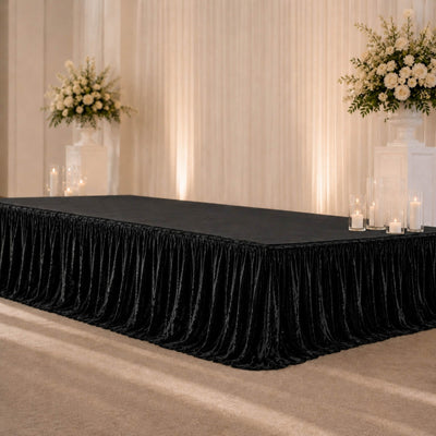 Elegant black velvet banquet table with white floral wedding decor and candles