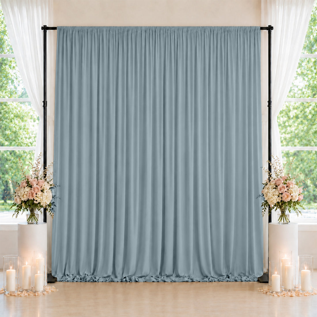 Elegant blue-gray wedding backdrop with floral arrangements and candle decor
