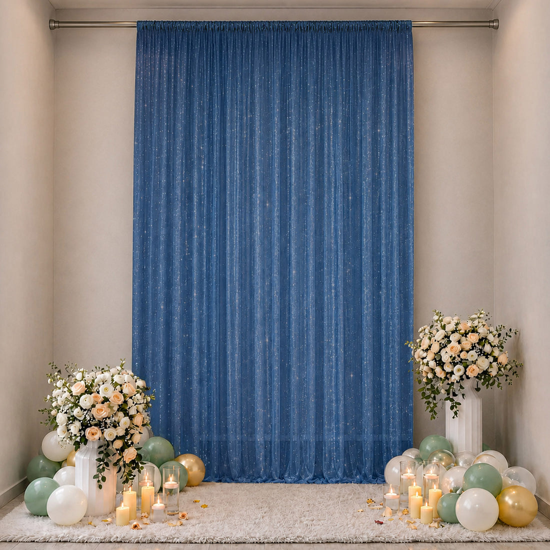 Elegant blue party backdrop with floral arrangements, candles, and balloons