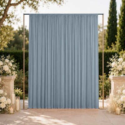 Elegant blue wedding backdrop with floral arrangements and candles outdoors