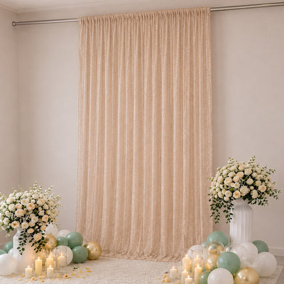 Elegant blush curtain backdrop with balloons, candles, and floral arrangements