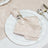 Elegant blush napkin with silver ring on white gold-rimmed dinner plate