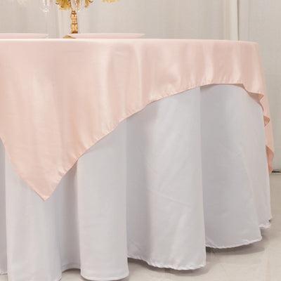 Pink satin tablecloth draped over a white table