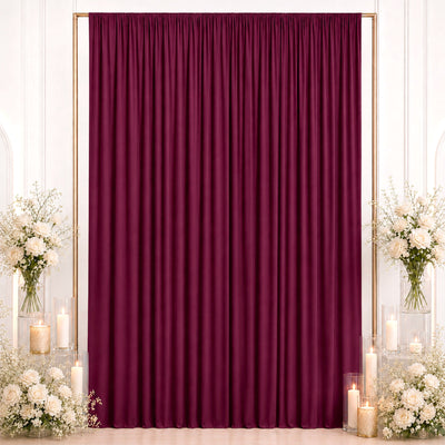Elegant burgundy curtain backdrop with white floral arrangements and candles