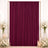 Elegant burgundy curtain backdrop with white floral arrangements and candles