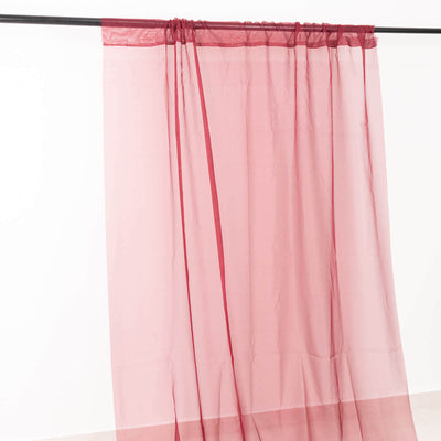 Sheer burgundy curtain panel hanging on a rod