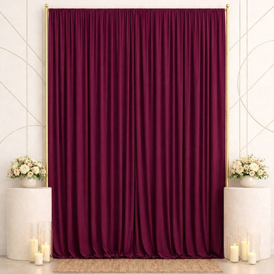 Elegant burgundy velvet backdrop with floral arrangements and candles