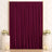 Elegant burgundy velvet backdrop with floral arrangements and candles