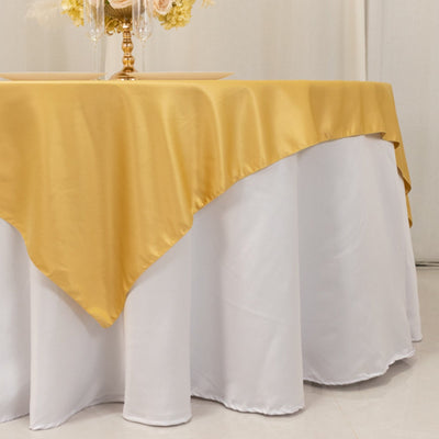 Yellow satin tablecloth draped over a white table.