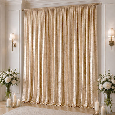 Elegant champagne velvet curtain backdrop with floral arrangements and candles