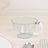 Clear plastic cup with a white handle and blue accent on a wooden surface.