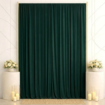 Elegant dark green curtain backdrop with floral arrangements and candles