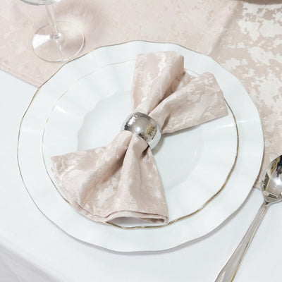 Elegant dining table setting with white plates, blush napkin and silver napkin ring