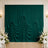 Elegant emerald green draped backdrop with floral arrangement in wedding venue