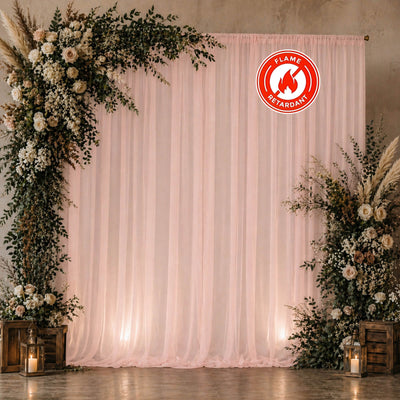 Elegant floral wedding backdrop with pink drapes and lanterns, flame retardant sign